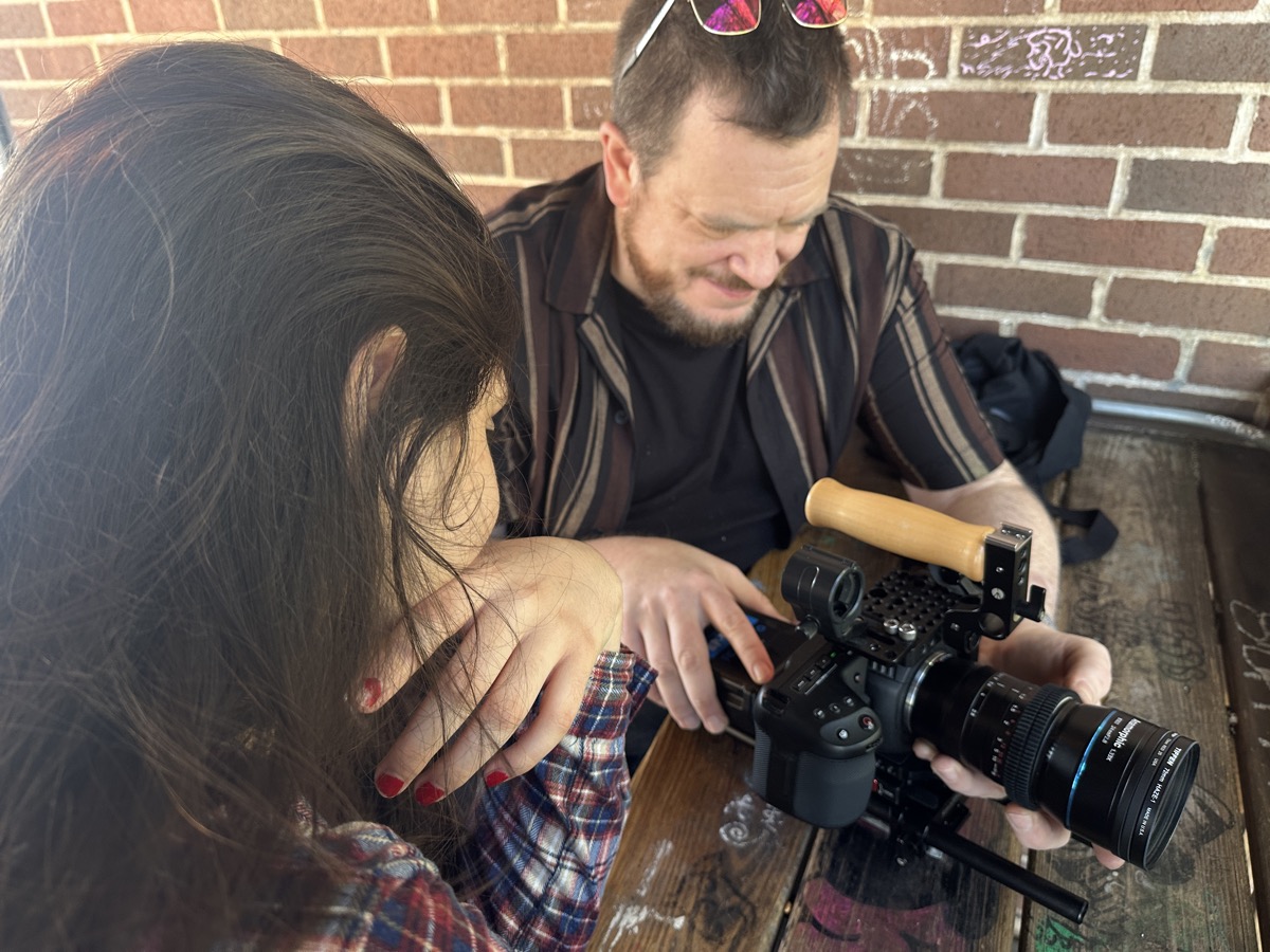 A teen crew member reviewing footage with a mentor