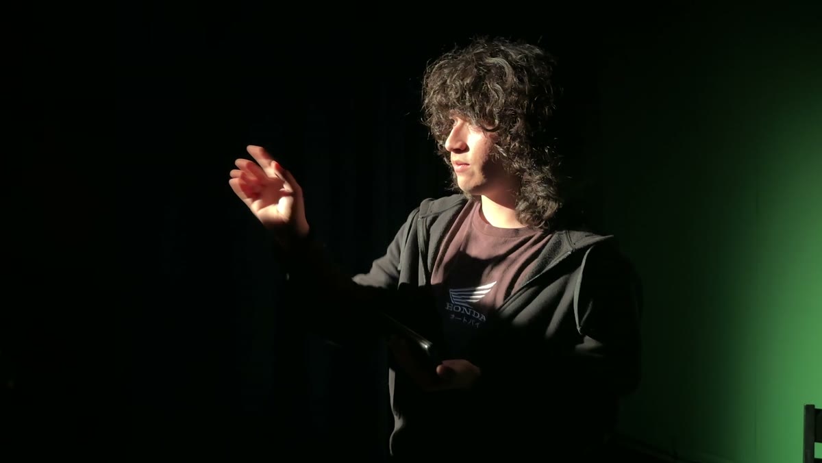 A student performing under studio lights at Austin Public