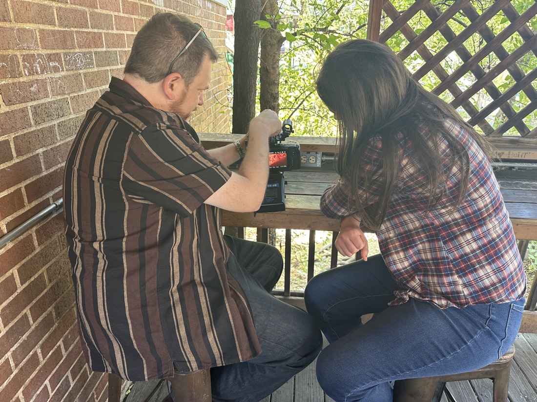 Instructor showing a teen how to set up the camera